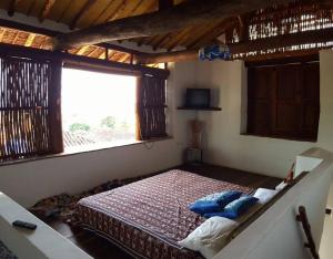 Cette chambre comprend un grand lit et une fenêtre. dans l'établissement Casa Tierrarte, à Barichara
