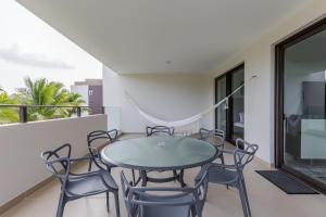 uma sala de jantar com uma mesa e cadeiras numa varanda em Lorena Ochoa Complex At Grand Coral em Playa del Carmen