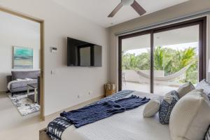 um quarto com uma cama, uma televisão e uma varanda em Lorena Ochoa Complex At Grand Coral em Playa del Carmen