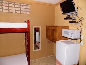 a room with a bunk bed and a tv at Léa Pousada in Fortaleza