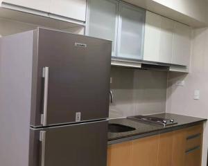 a kitchen with a stainless steel refrigerator and cabinets at ONE UPTOWN RESIDENCE in Manila
