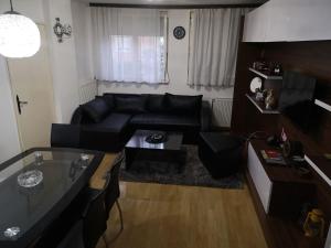 a living room with a black couch and a table at Guest House Villa Krstic in Pirot