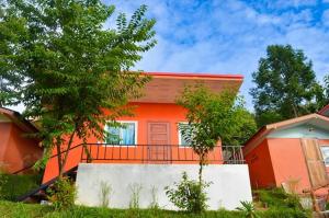 a orange house with a fence in front of it at Mon View Doi in Chiang Mai