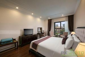 a hotel room with a bed and a television at Adonis Hotel in Hanoi