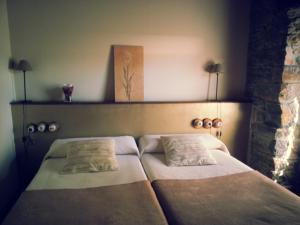 a bed with two pillows on it in a room at Hostal De Montaña La Aldeya in Villablino