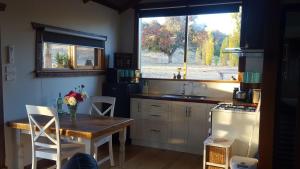 a kitchen with a table and a sink and a window at Baroona Cottage in Barwite