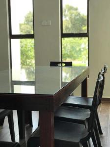 a dining room table with two chairs and a window at Orchard Villa Melaka in Malacca +19 photos