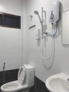 a bathroom with a shower and a toilet and a sink at Orchard Villa Melaka in Melaka