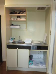 a small kitchen with a sink and a counter at Comfort CUBE PHOENIX S Kumamoto in Kumamoto