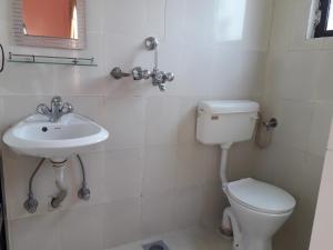 a bathroom with a toilet and a sink at Seven Steps Guest House in Muglaha