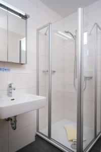 W łazience znajduje się prysznic i umywalka. w obiekcie Hotel Nora w mieście Bad Krozingen