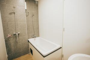 a bathroom with a shower and a sink and a toilet at Casa Coco Hotel in Nakhon Ratchasima