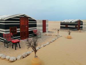 dos chozas en la arena en el desierto en Legend Desert camp, en Fulayj al Mashāʼikh