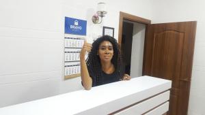 une femme debout derrière un comptoir dans une salle de bains dans l'établissement Hostel Bravo, à Ferghana