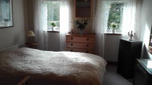 a bedroom with a bed and two windows and a dresser at Holtens Gaard in Hobro