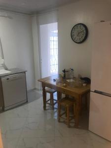 a kitchen with a wooden table and a clock on the wall at Casa chicas Two bedroom Apartment in Birmandreis +1 photo