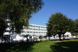 a large white building with trees in front of it at Zefir Hotel in Sunny Beach