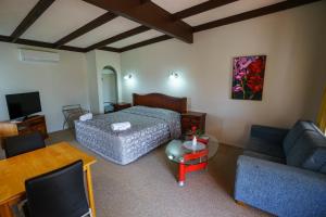 - un salon avec un lit et un canapé dans l'établissement Casa Mexicana, à Paeroa