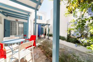 a patio with red chairs and a blue table at Fivos Apartments in Aliki