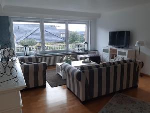 ein Wohnzimmer mit Sofas und einem großen Fenster in der Unterkunft Bei Bille und Jan in Bad Bentheim