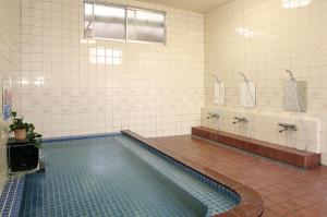 a large bathroom with a swimming pool and a tub at Yawarano-yu MARUYA For women only in Ise