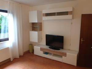 a living room with a flat screen tv on a wall at Andinas Ferienwohnung in ruhiger Lage direkt am Wald in Wilnsdorf