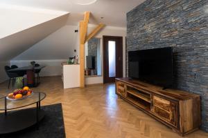 uma sala de estar com uma grande televisão numa parede de tijolos em Areal Botanika em Unhošť