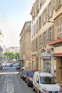 une rue avec des voitures garées sur le côté d'un bâtiment dans l'établissement Loft Luxe Réformé, à Marseille