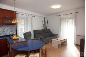 cocina y sala de estar con mesa azul en Piso das Costureiras en Pontevedra