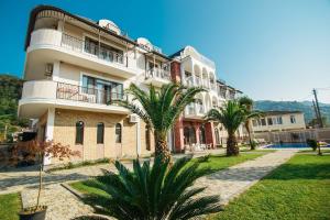 un grand bâtiment avec des palmiers devant lui dans l'établissement Bude, à Gonio