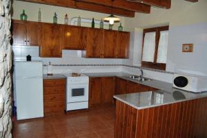 - une cuisine avec des appareils blancs et des armoires en bois dans l'établissement CAL TORT, à Maia de Montcal