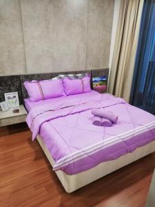 Cama púrpura con sábanas y almohadas púrpuras en LAVENDER Suite@I_CITY en Shah Alam
