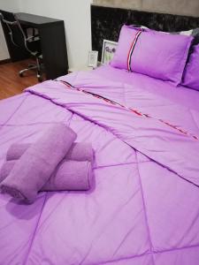 Cama púrpura con almohadas púrpuras y sábanas púrpuras en LAVENDER Suite@I_CITY en Shah Alam