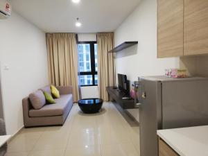 a small living room with a couch and a refrigerator at LAVENDER Suite@I_CITY in Shah Alam