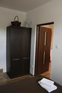 a bedroom with a brown cabinet and a door at M&M apartamenty in Zamość