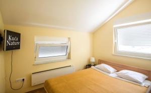 um quarto com uma cama e uma janela em Kuća za odmor Nature em Cerje