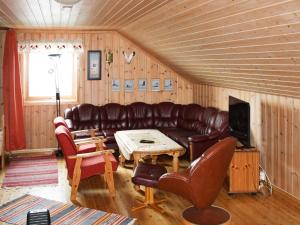 a living room with a leather couch and a table at 6 person holiday home in Brekstad in Brekstad