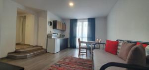 a living room with a couch and a table and a kitchen at Guest House Malusha in Gabrovo