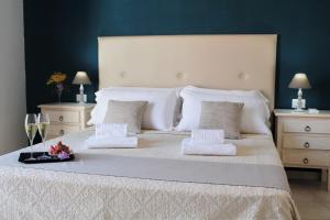 a bedroom with a large bed with white sheets and pillows at AHR Leonis Residence La Maddalena in La Maddalena