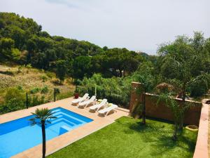 einen Außenpool mit Liegestühlen und einem Pool in der Unterkunft Casa con vistas al mar y piscina privada in Lloret de Mar