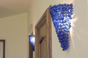 un montón de adornos de cristal azul colgando de una pared en Amore Rentals - Villa Il Pino, en SantʼAgata sui Due Golfi