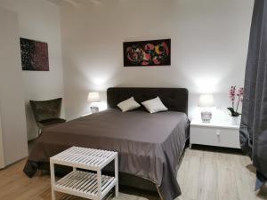 Un dormitorio con una cama, una silla y una mesa. en Judaica d'Ortigia, en Siracusa