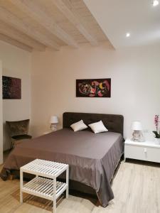 Un dormitorio con una cama grande y una mesa. en Judaica d'Ortigia, en Siracusa