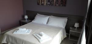 a bed with a white comforter and pillows at Borgo Palombaio 2 in Catania