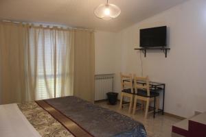 a bedroom with a bed and a table and a television at Casa Madè in Chieti