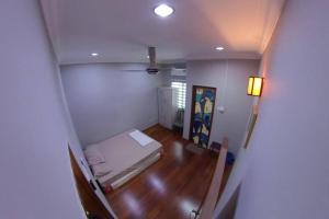 Habitación pequeña con cama y suelo de madera. en Selangor Klang Homestay, en Klang