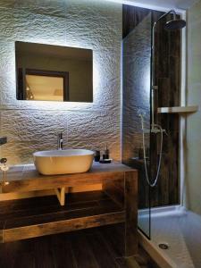 La salle de bains est pourvue d'un lavabo, d'un miroir et d'une douche. dans l'établissement Guesthouse Kastelia, à Kalambaka