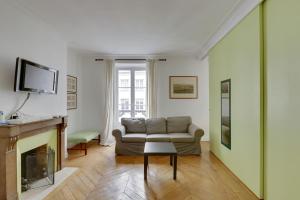 a living room with a couch and a fireplace at Unit 009 - Saint Germain des Près (Cherche Midi) in Paris