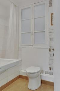a white bathroom with a toilet and a bath tub at Unit 009 - Saint Germain des Près (Cherche Midi) in Paris