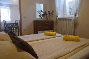 Duas camas num quarto com almofadas amarelas. em APARTMENT TERRA, Koper center em Koper